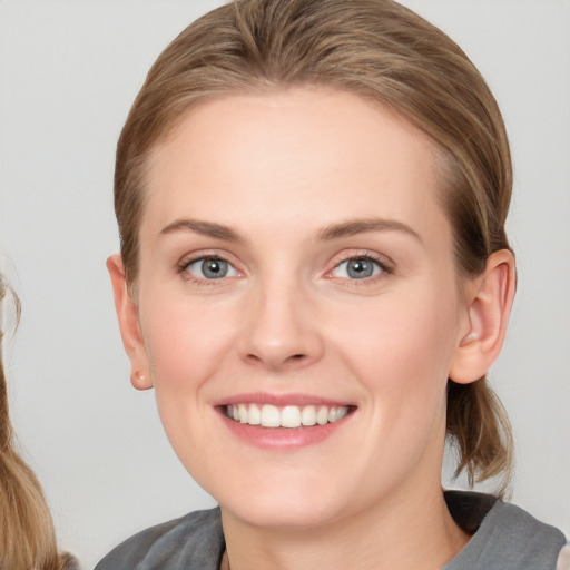 Joyful white young-adult female with long  brown hair and blue eyes