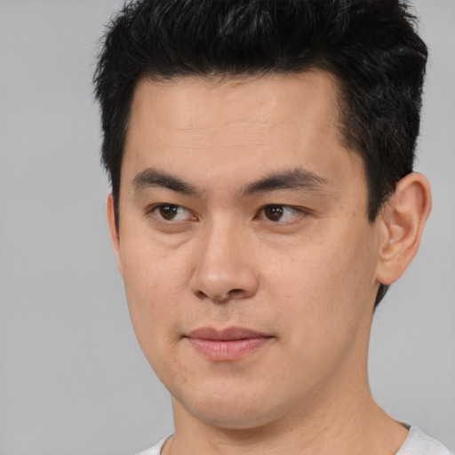 Joyful asian young-adult male with short  brown hair and brown eyes
