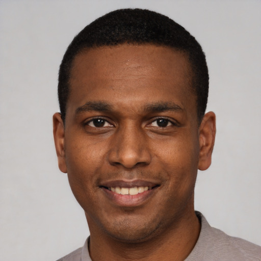 Joyful black young-adult male with short  black hair and brown eyes