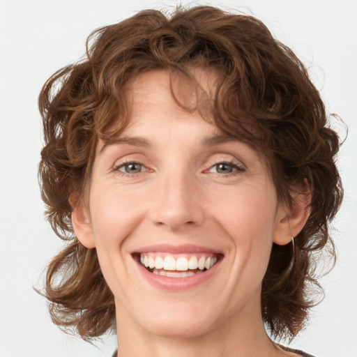 Joyful white young-adult female with medium  brown hair and green eyes