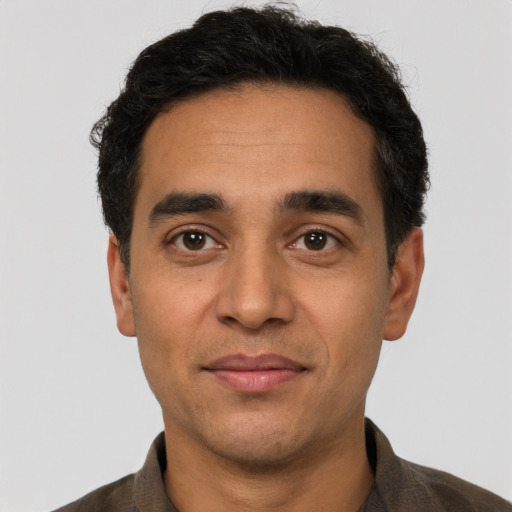 Joyful latino adult male with short  black hair and brown eyes