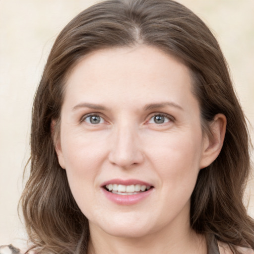 Joyful white young-adult female with long  brown hair and grey eyes