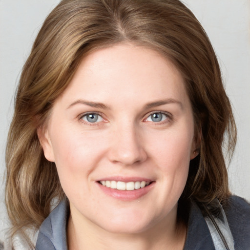 Joyful white young-adult female with medium  brown hair and blue eyes