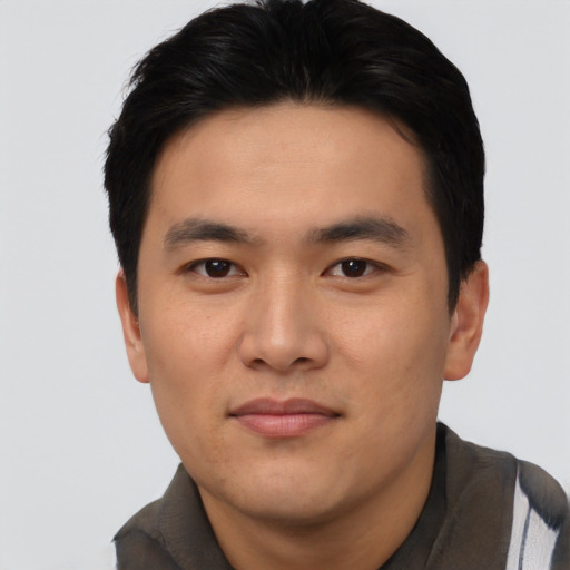 Joyful asian young-adult male with short  black hair and brown eyes