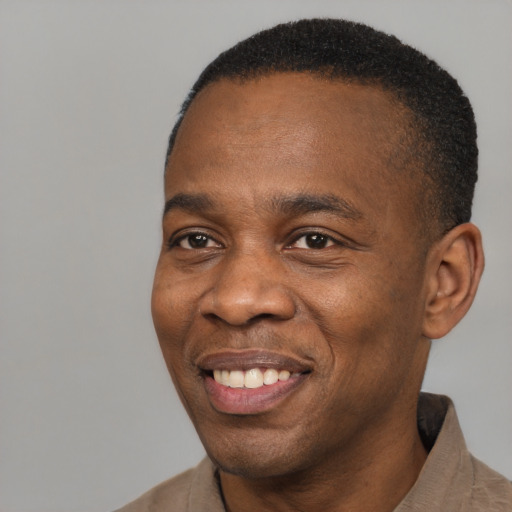 Joyful black adult male with short  brown hair and brown eyes