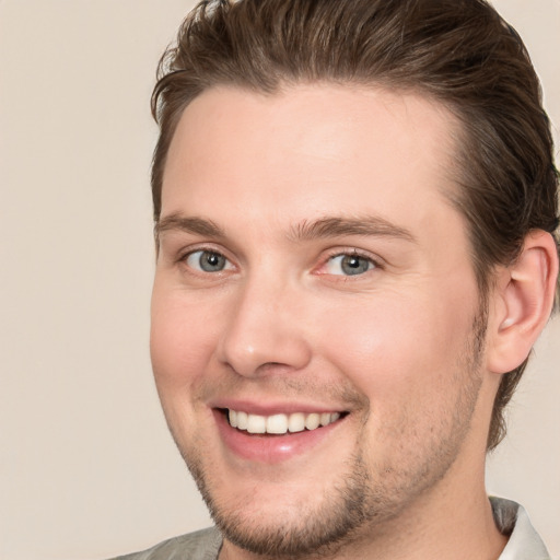 Joyful white young-adult male with short  brown hair and grey eyes