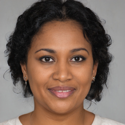 Joyful black young-adult female with medium  brown hair and brown eyes