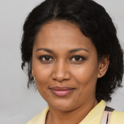 Joyful black adult female with medium  brown hair and brown eyes