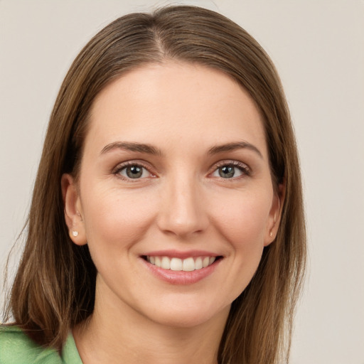 Joyful white young-adult female with long  brown hair and green eyes