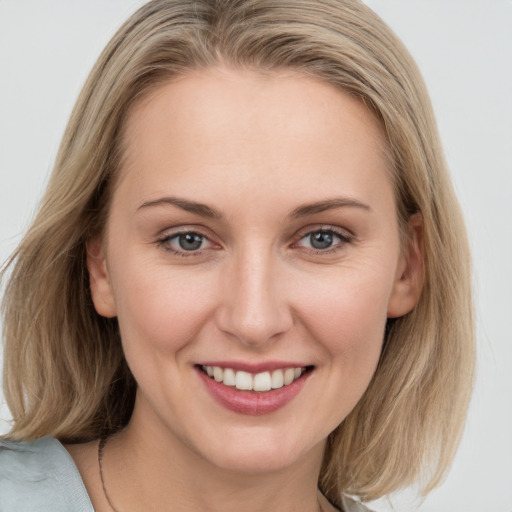 Joyful white young-adult female with medium  brown hair and blue eyes