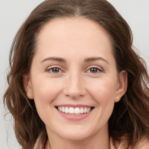 Joyful white young-adult female with long  brown hair and grey eyes