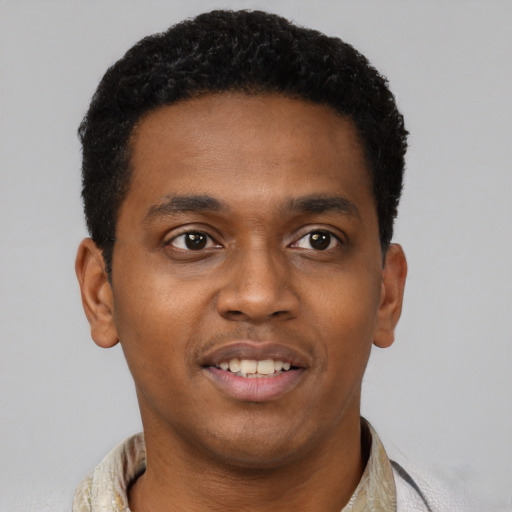 Joyful black young-adult male with short  brown hair and brown eyes