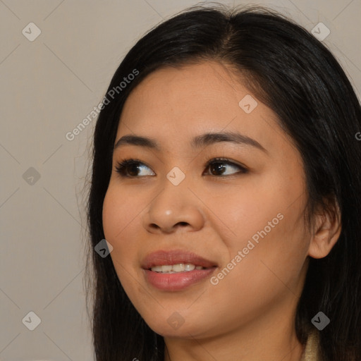 Joyful asian young-adult female with long  brown hair and brown eyes