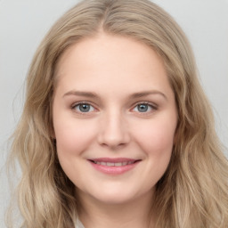 Joyful white young-adult female with long  brown hair and blue eyes