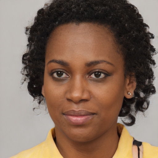 Joyful black young-adult female with medium  brown hair and brown eyes