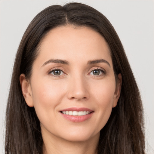 Joyful white young-adult female with long  brown hair and brown eyes