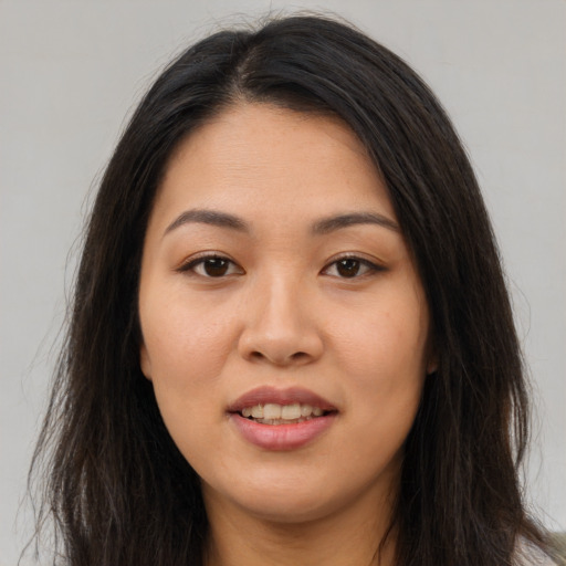Joyful asian young-adult female with long  brown hair and brown eyes