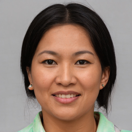 Joyful asian young-adult female with medium  black hair and brown eyes