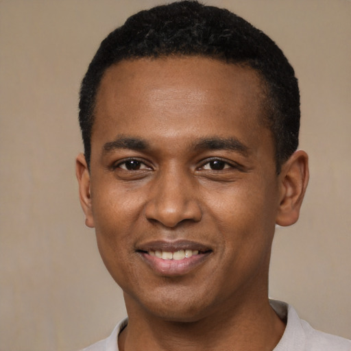 Joyful black young-adult male with short  black hair and brown eyes