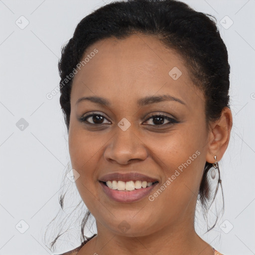 Joyful black young-adult female with medium  brown hair and brown eyes