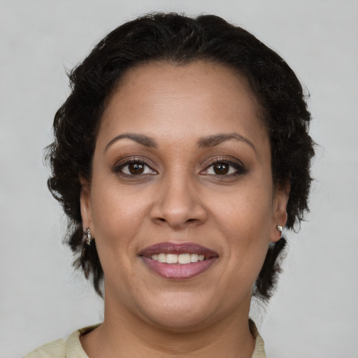 Joyful latino adult female with medium  brown hair and brown eyes