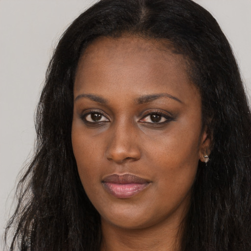 Joyful black young-adult female with long  brown hair and brown eyes
