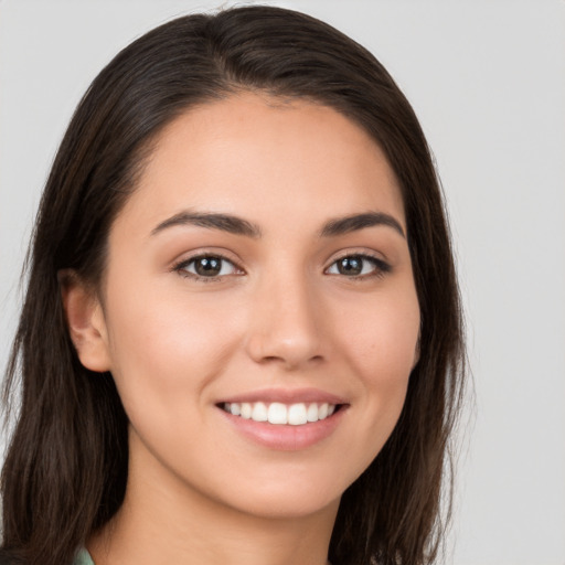 Joyful white young-adult female with long  brown hair and brown eyes