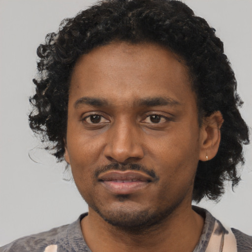 Joyful black young-adult male with short  black hair and brown eyes