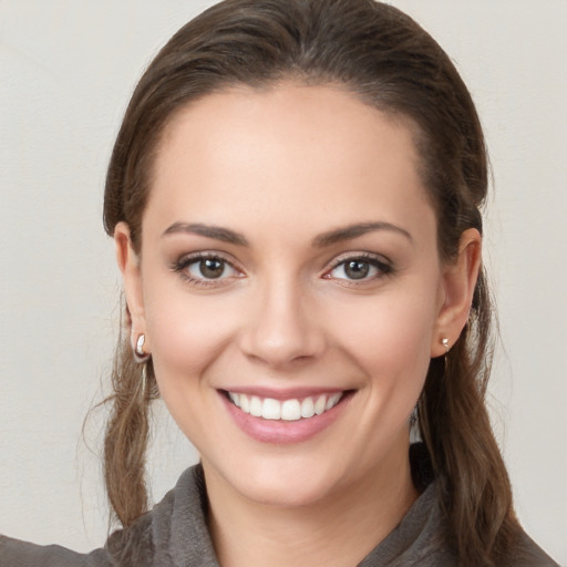 Joyful white young-adult female with long  brown hair and grey eyes