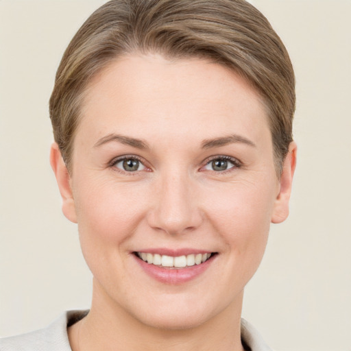 Joyful white young-adult female with short  brown hair and grey eyes