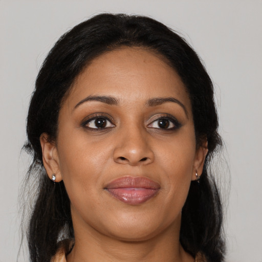 Joyful black adult female with long  brown hair and brown eyes