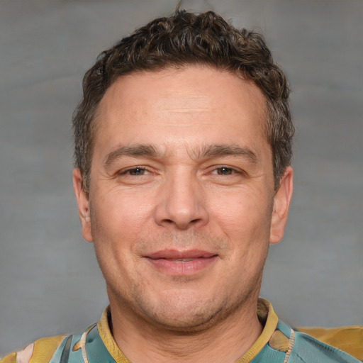 Joyful white adult male with short  brown hair and brown eyes