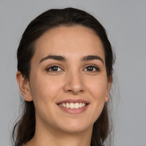 Joyful white young-adult female with long  brown hair and brown eyes