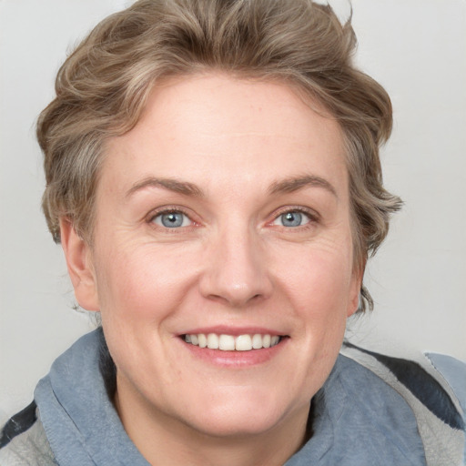 Joyful white adult female with medium  brown hair and blue eyes