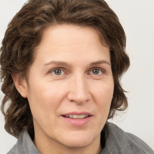 Joyful white adult female with medium  brown hair and grey eyes