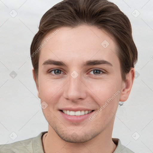 Joyful white young-adult male with short  brown hair and grey eyes