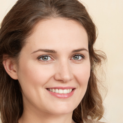 Joyful white young-adult female with medium  brown hair and green eyes