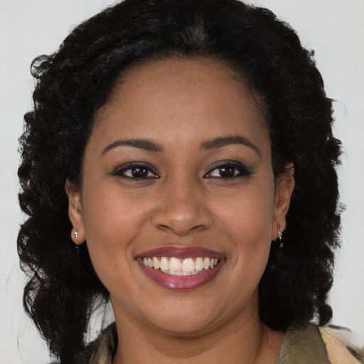 Joyful black adult female with long  brown hair and brown eyes