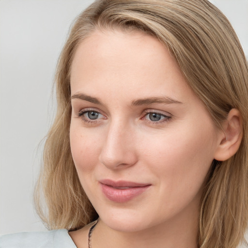 Joyful white young-adult female with long  brown hair and blue eyes