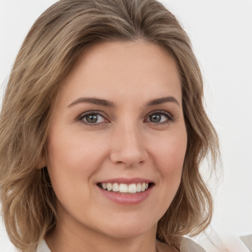 Joyful white young-adult female with medium  brown hair and green eyes