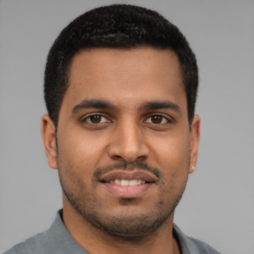 Joyful latino young-adult male with short  black hair and brown eyes