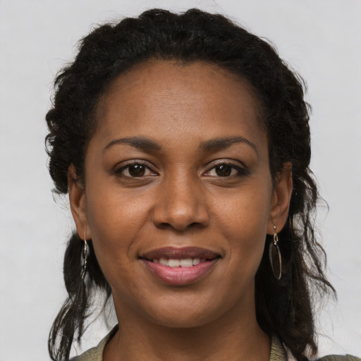 Joyful black young-adult female with long  brown hair and brown eyes