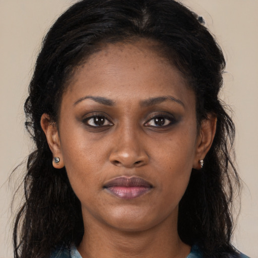 Joyful black young-adult female with long  brown hair and brown eyes