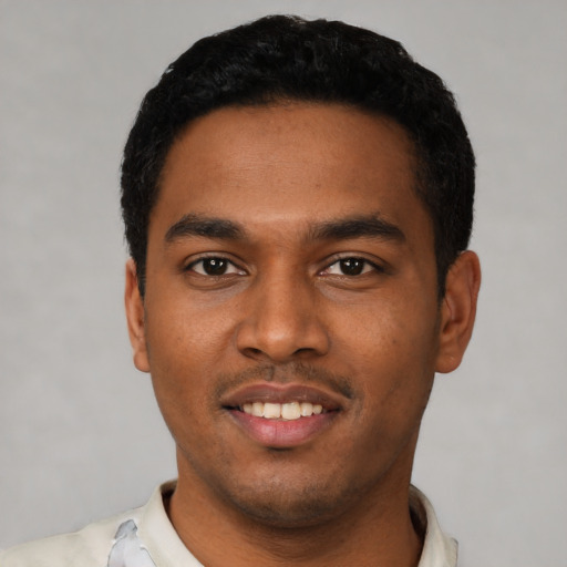 Joyful latino young-adult male with short  black hair and brown eyes