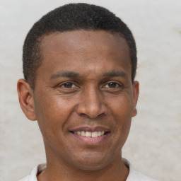 Joyful latino young-adult male with short  brown hair and brown eyes