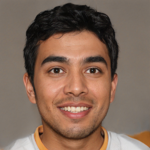 Joyful latino young-adult male with short  brown hair and brown eyes