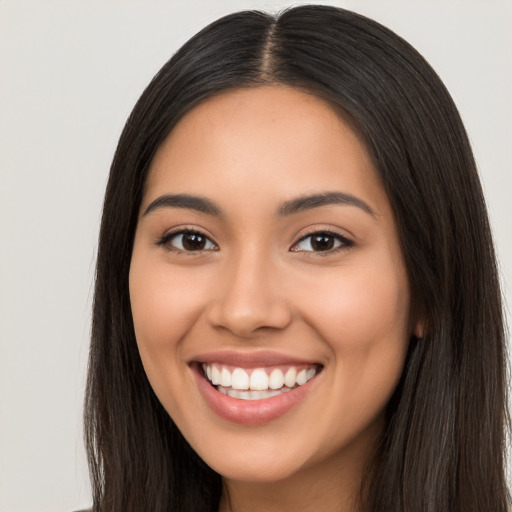 Joyful latino young-adult female with long  black hair and brown eyes