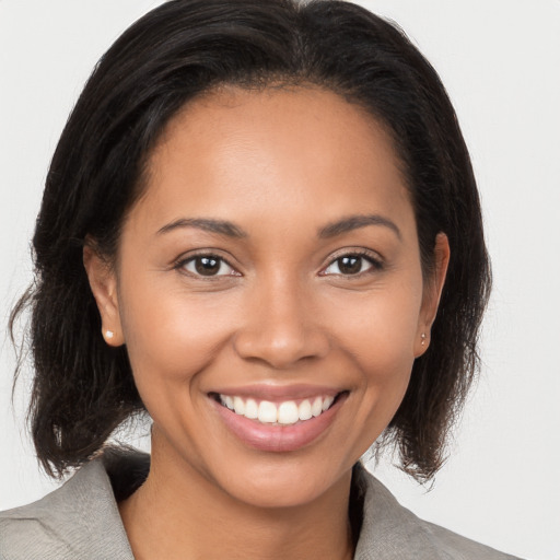 Joyful latino young-adult female with medium  brown hair and brown eyes