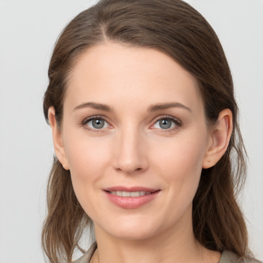 Joyful white young-adult female with long  brown hair and grey eyes