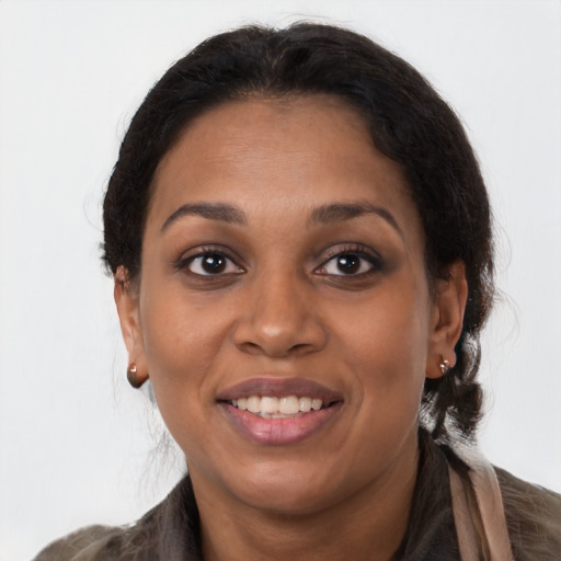 Joyful black adult female with long  brown hair and brown eyes
